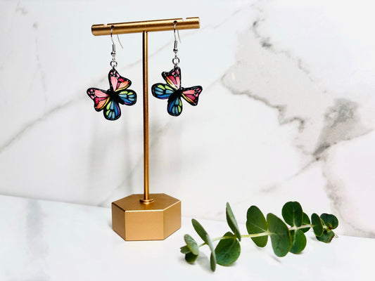 Butterfly earrings on a gold display stand