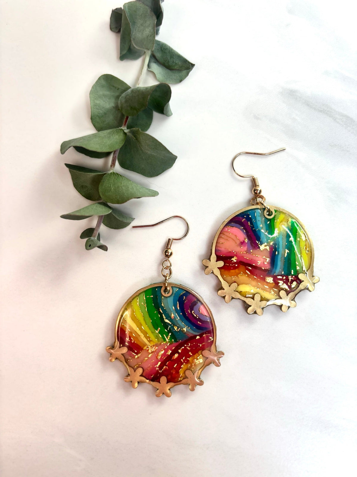 Rainbow bezel earrings on a marble background