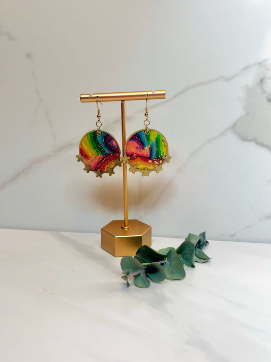 Rainbow bezel earrings on a gold display stand